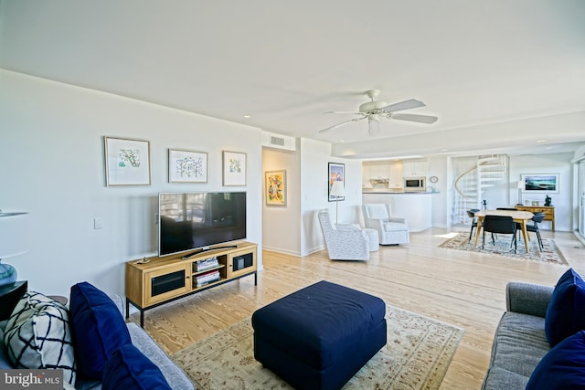 living area featuring ceiling fan and light wood-style floors