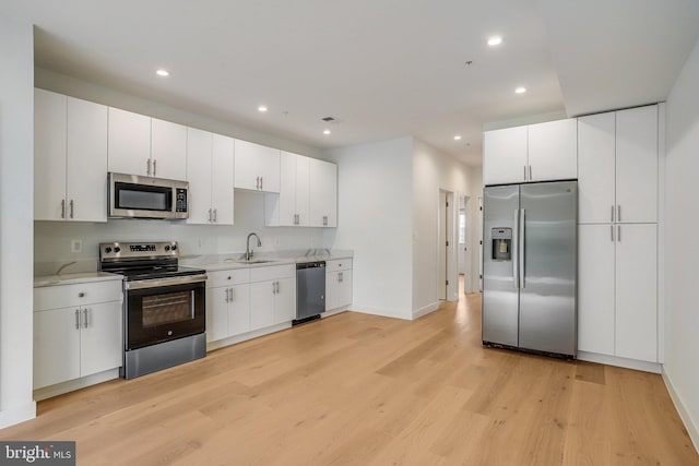 4902 D St SE, Washington, DC 20019 - kitchen with stainless steel appliances, a sink, light wood-type flooring, light countertops, and recessed lighting
