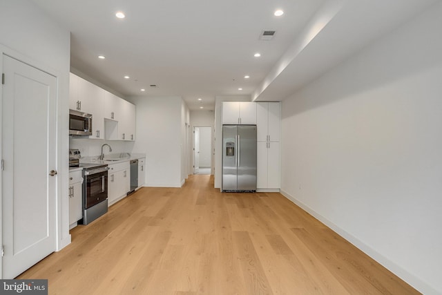 4902 D St SE, Washington, DC 20019 - kitchen featuring stainless steel appliances, a sink, white cabinetry, recessed lighting, and light countertops
