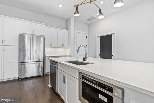 44691 Wellfleet Dr Unit 508, Ashburn, VA 20147 - kitchen with appliances with stainless steel finishes, a sink, white cabinets, light stone countertops, and decorative backsplash