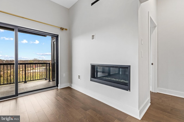44691 Wellfleet Dr Unit 508, Ashburn, VA 20147 - unfurnished living room featuring wood finished floors, a glass covered fireplace, and baseboards