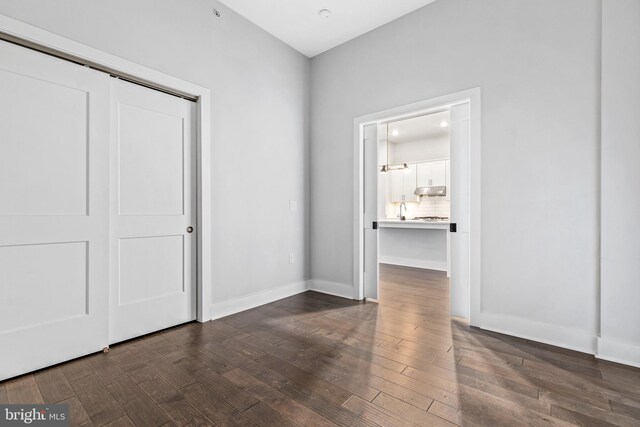 44691 Wellfleet Dr Unit 508, Ashburn, VA 20147 - unfurnished bedroom with dark wood-type flooring, a closet, baseboards, and a sink