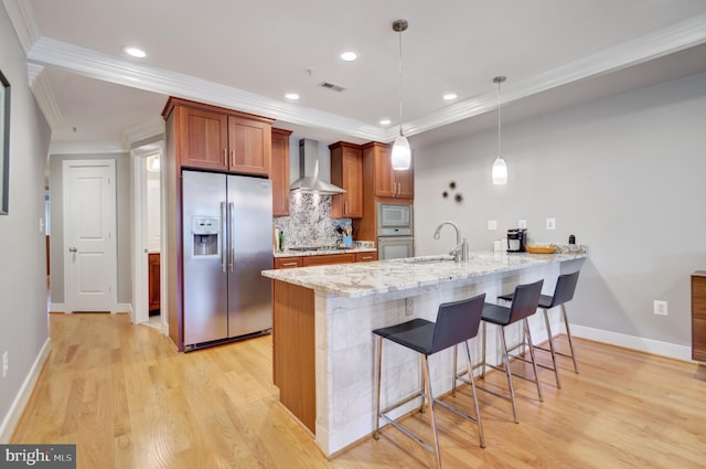2448 Ontario Rd NW Unit 3, Washington, DC 20009 - kitchen featuring stainless steel appliances, wall chimney exhaust hood, a sink, a peninsula, and a breakfast bar area