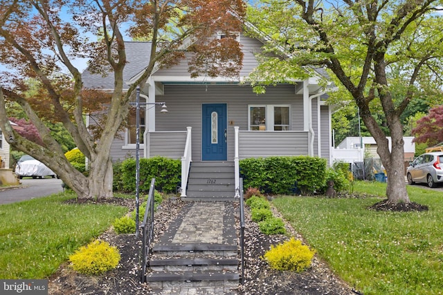 view of front of house featuring covered porch and a front lawn