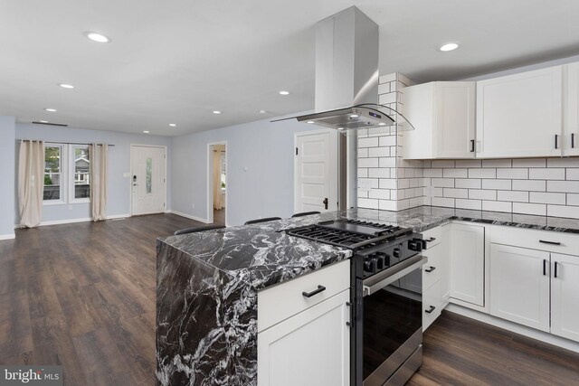 kitchen featuring stainless steel range with gas cooktop, wall chimney range hood, dark stone counters, dark wood-type flooring, and recessed lighting
