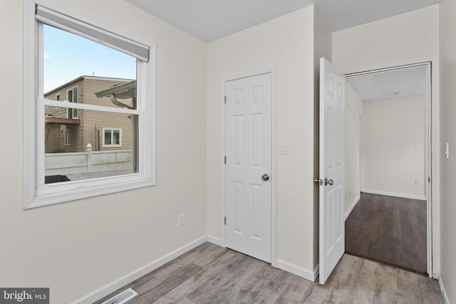 unfurnished bedroom featuring wood finished floors and baseboards