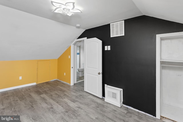 additional living space with lofted ceiling and light wood-type flooring