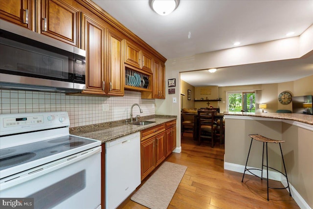 915 Burberry Ct, Sicklerville, NJ 08081 - kitchen featuring white appliances, a sink, brown cabinets, light wood finished floors, and decorative backsplash