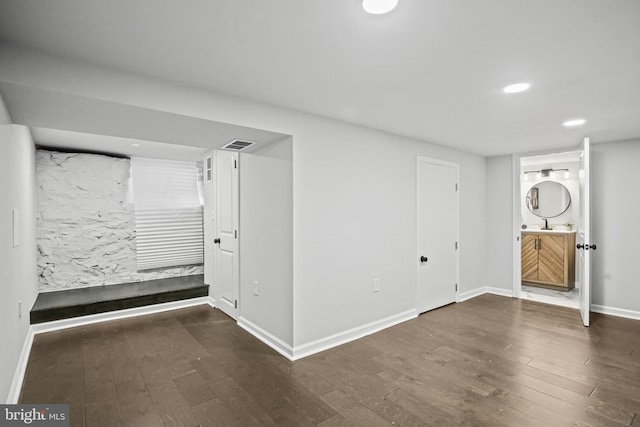 finished basement with wood finished floors, baseboards, recessed lighting, and a sink
