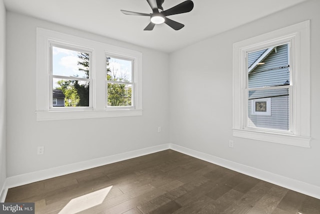 empty room with dark wood-style floors, baseboards, and ceiling fan