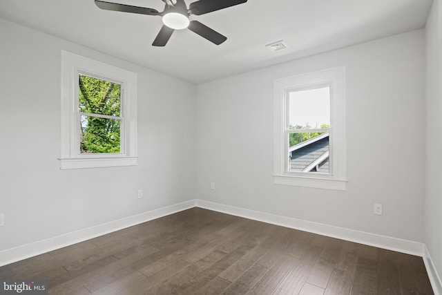 empty room featuring baseboards, dark wood-style flooring, and a ceiling fan
