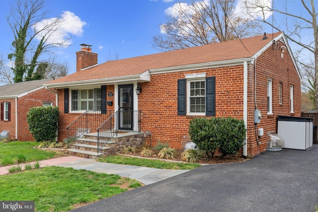 304 Moncure Dr, Alexandria, VA 22314 - view of front facade featuring brick siding, a chimney, and a front yard