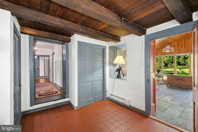 interior space featuring dark tile patterned flooring, beamed ceiling, baseboard heating, wood ceiling, and baseboards