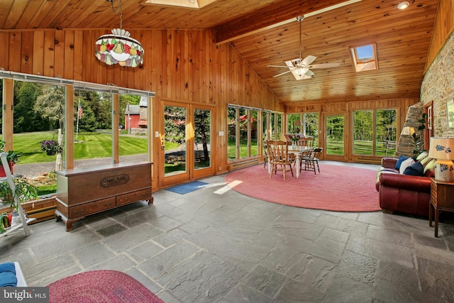 sunroom featuring lofted ceiling with skylight, french doors, and stone tile flooring