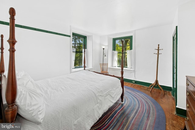 bedroom with baseboards and wood finished floors