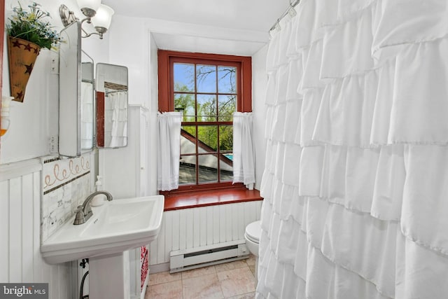 full bath with a baseboard heating unit