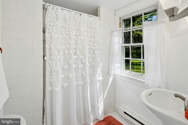 full bathroom featuring a wealth of natural light, a baseboard radiator, and curtained shower