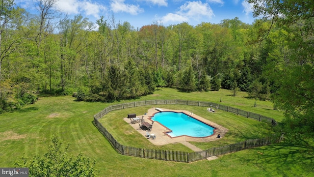 view of pool with a diving board, a lawn, and a fenced backyard