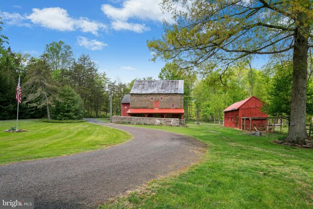 view of front facade with an outdoor structure, a front lawn, and a barn