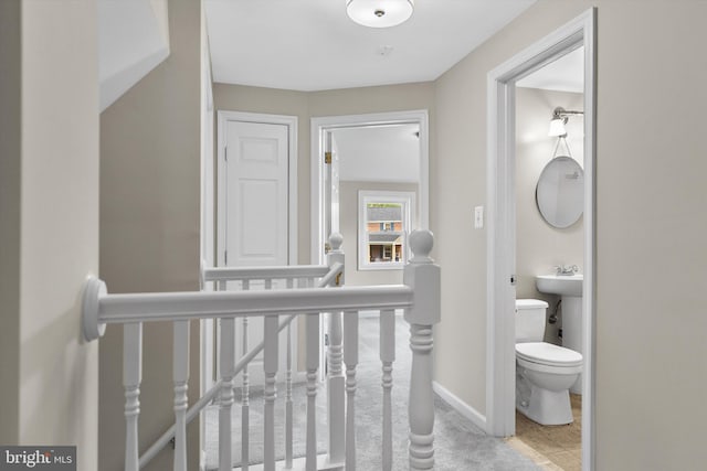 hallway with baseboards and tile patterned floors