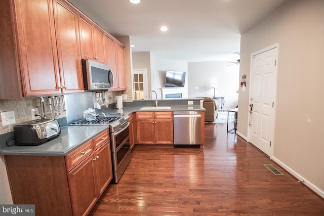 23371 Hosta Ln, California, MD 20619 - kitchen featuring stainless steel appliances, a sink, a peninsula, dark wood-type flooring, and open floor plan