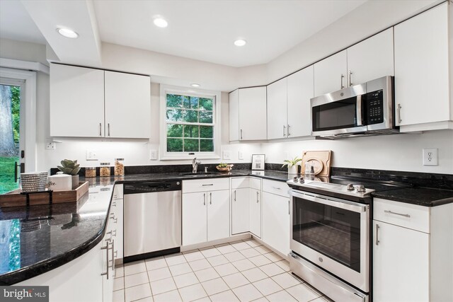 kitchen featuring stainless steel appliances, healthy amount of natural light, white cabinets, a sink, and recessed lighting