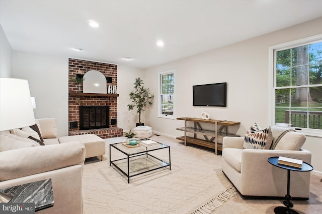 living area featuring baseboards, a brick fireplace, recessed lighting, and light carpet