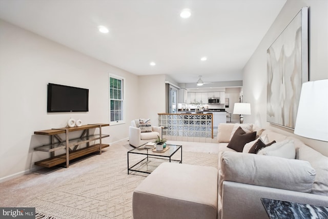 living area featuring baseboards, light colored carpet, and recessed lighting