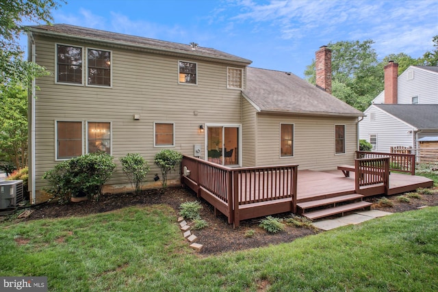 rear view of house featuring a yard, cooling unit, a deck, and a chimney