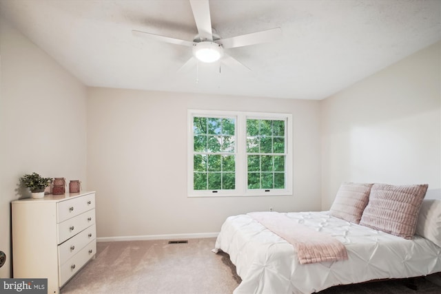 bedroom with light colored carpet, baseboards, and ceiling fan