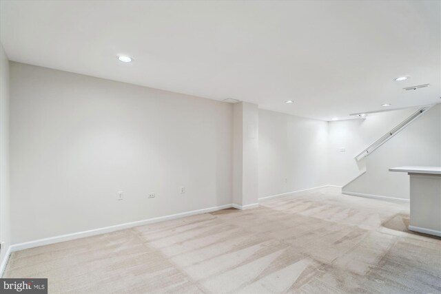 finished below grade area with light carpet, recessed lighting, and baseboards