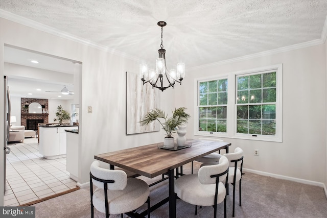 dining room with a chandelier, baseboards, a brick fireplace, crown molding, and a textured ceiling