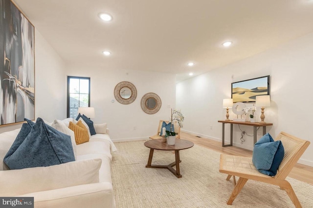 living room with light wood-style floors, baseboards, and recessed lighting