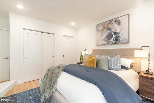bedroom featuring a closet, wood finished floors, and recessed lighting