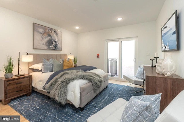 bedroom with recessed lighting, wood finished floors, and access to exterior