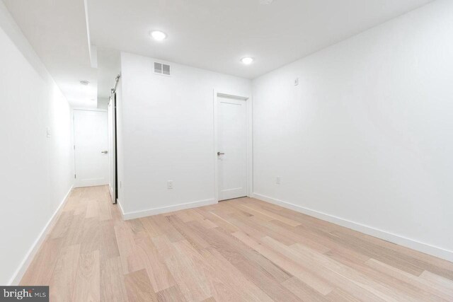 spare room featuring light wood finished floors, visible vents, baseboards, and recessed lighting