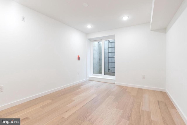 unfurnished room with baseboards, light wood finished floors, and recessed lighting