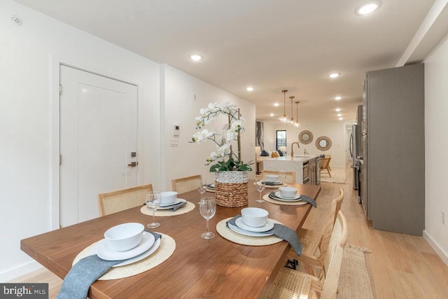 dining space with light wood-type flooring, baseboards, and recessed lighting
