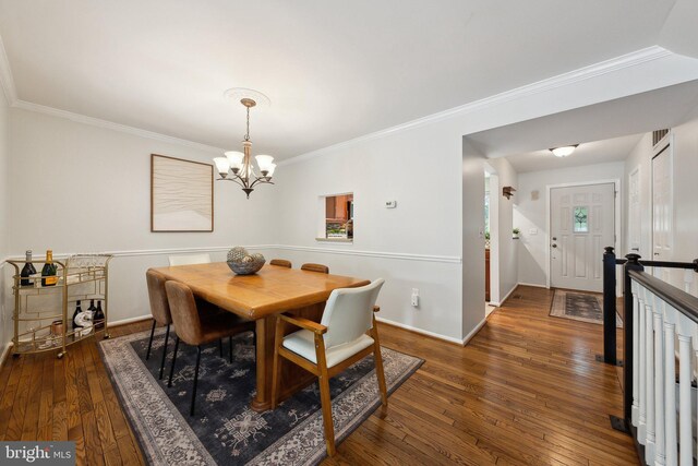 dining area with a chandelier, ornamental molding, dark wood-type flooring, and baseboards