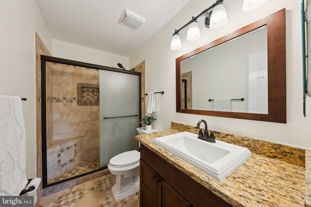 full bath featuring a stall shower, toilet, and vanity