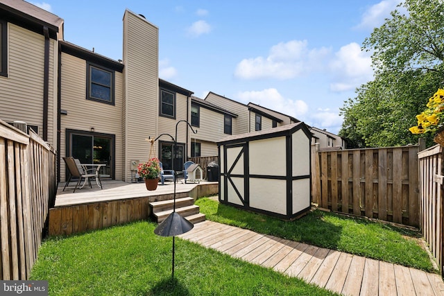 back of property featuring a storage unit, an outbuilding, a wooden deck, and a chimney