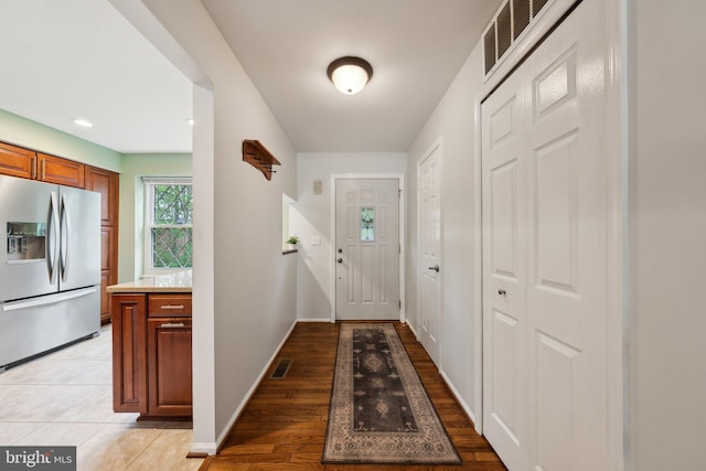 doorway featuring baseboards and light wood-type flooring
