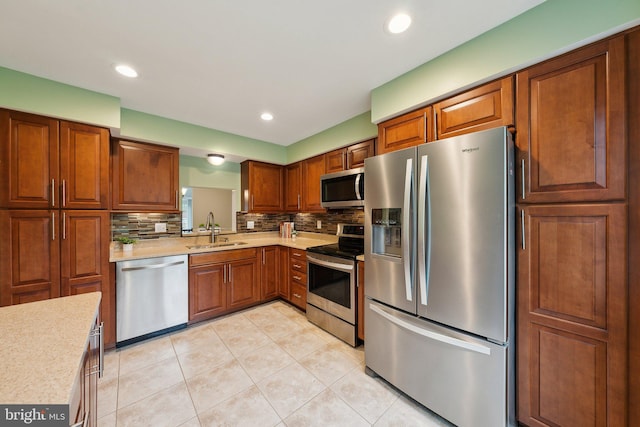 kitchen with appliances with stainless steel finishes, a sink, light countertops, decorative backsplash, and recessed lighting