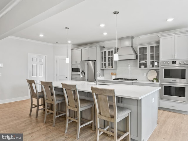 35015 Kindleton Ln, Lewes, DE 19958 - kitchen featuring appliances with stainless steel finishes, premium range hood, a sink, ornamental molding, and a large island