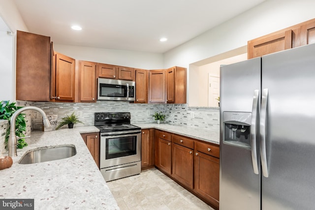 1020 Thomas Rd, Glen Burnie, MD 21060 - kitchen featuring stainless steel appliances, a sink, backsplash, light stone countertops, and brown cabinetry