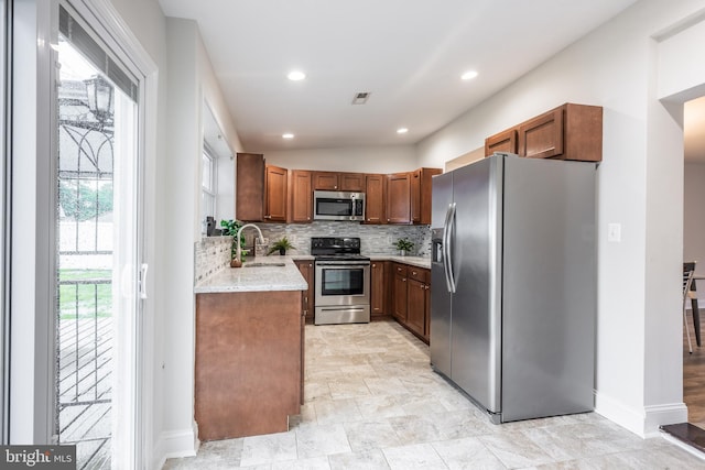 1020 Thomas Rd, Glen Burnie, MD 21060 - kitchen with stainless steel appliances, backsplash, baseboards, a sink, and light stone counters