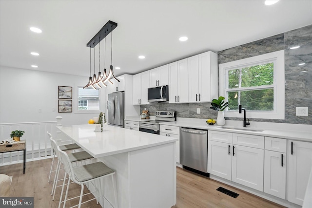 8224 Old Mill Rd, Pasadena, MD 21122 - kitchen with stainless steel appliances, a sink, plenty of natural light, white cabinets, and recessed lighting