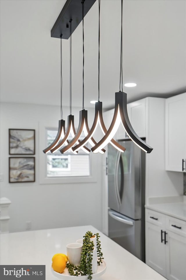 8224 Old Mill Rd, Pasadena, MD 21122 - kitchen featuring freestanding refrigerator, white cabinets, light countertops, and a chandelier