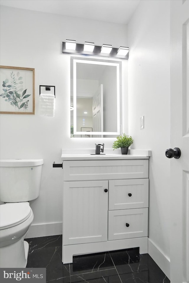 8224 Old Mill Rd, Pasadena, MD 21122 - half bath featuring baseboards, marble look tile flooring, toilet, and vanity