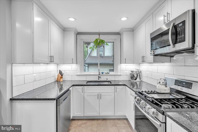 628 Mason Ave, Drexel Hill, PA 19026 - kitchen featuring appliances with stainless steel finishes, a sink, white cabinetry, dark stone countertops, and decorative backsplash
